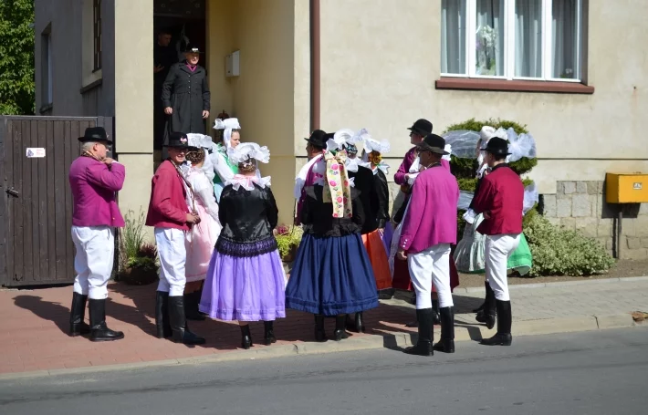 Grupa osób w strojach biskupiańskich przed domem