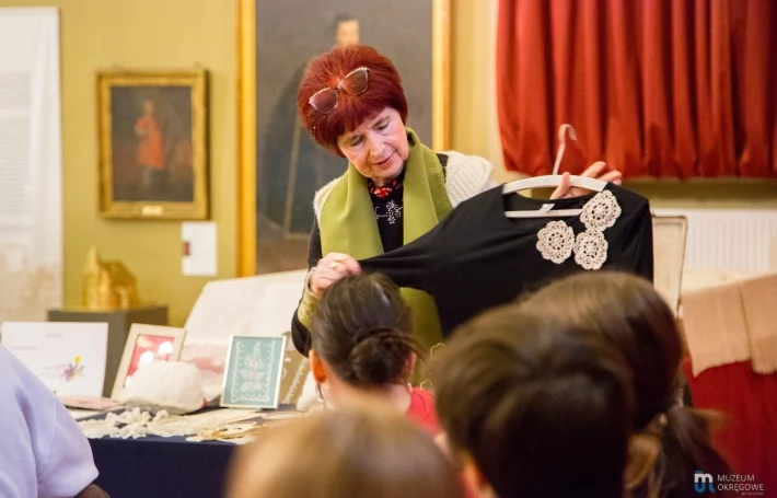 Grażyna Konopka pokazuje ręczne aplikacje na współczesnych ubraniach