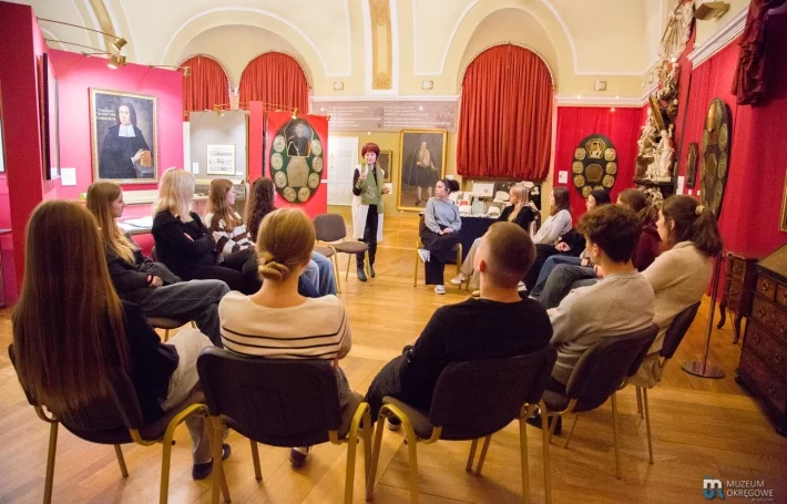 Grażyna Konopka prezentuje swe wyroby hafciarskie młodzieży